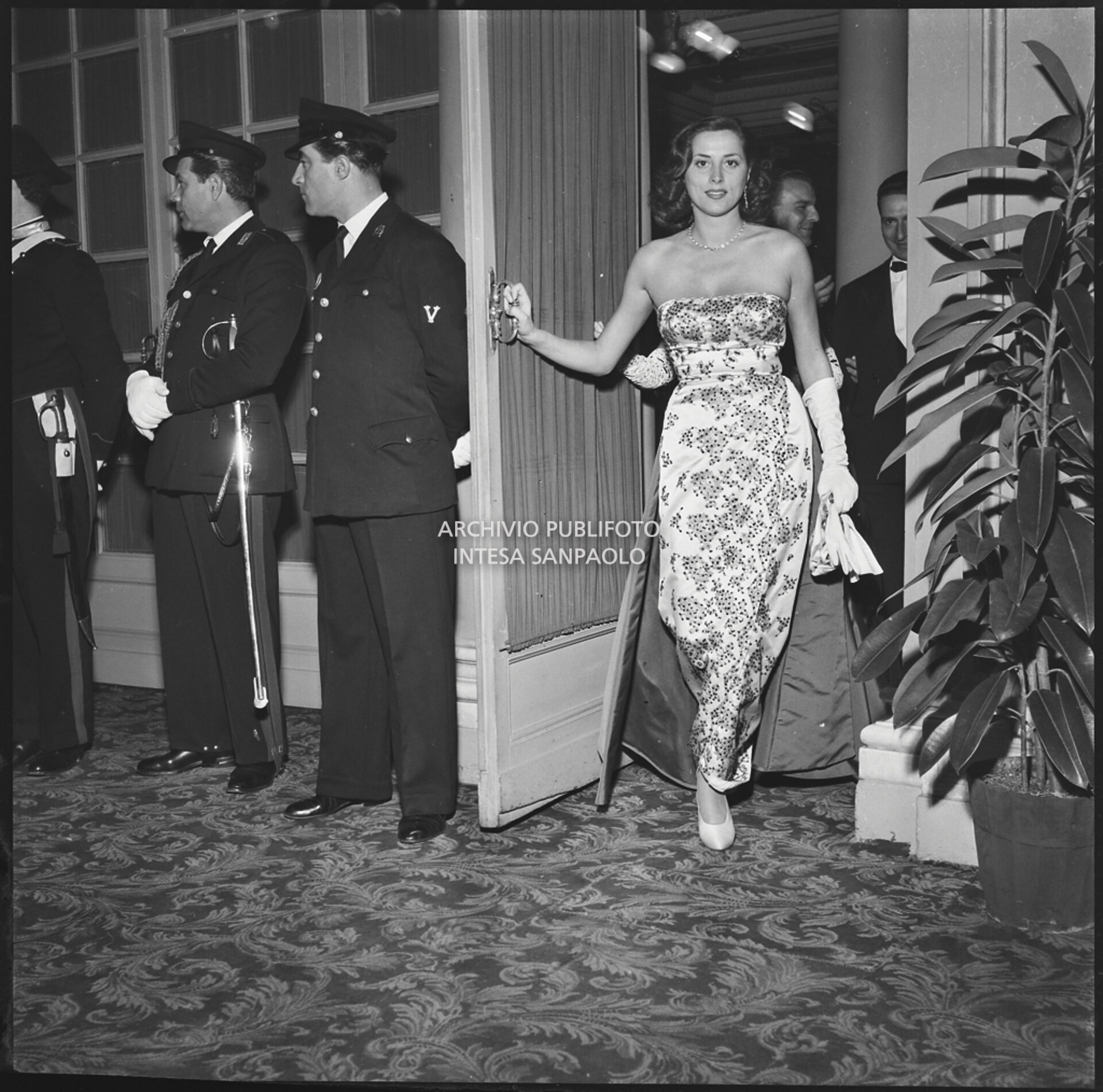 Una spettatrice al suo ingresso nel foyer del Teatro alla Scala la sera dell'inaugurazione della stagione lirica 1951-1952 con l'opera "I vespri siciliani" di Giuseppe Verdi, diretta da Victor de Sabata, con la regia di Herbert Graf