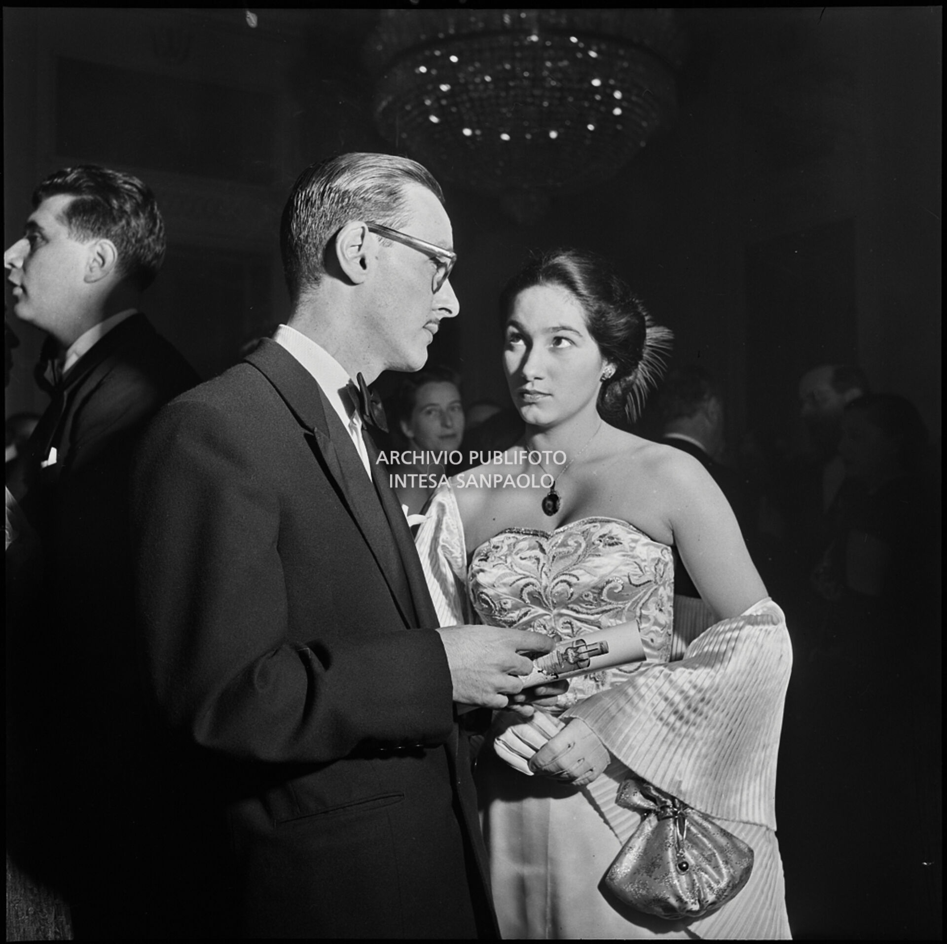 Spettatori nel foyer del Teatro alla Scala in occasione della serata inaugurale della stagione lirica 1951-1952 con l'opera "I vespri siciliani" di Giuseppe Verdi, diretta da Victor de Sabata, con la regia di Herbert Graf