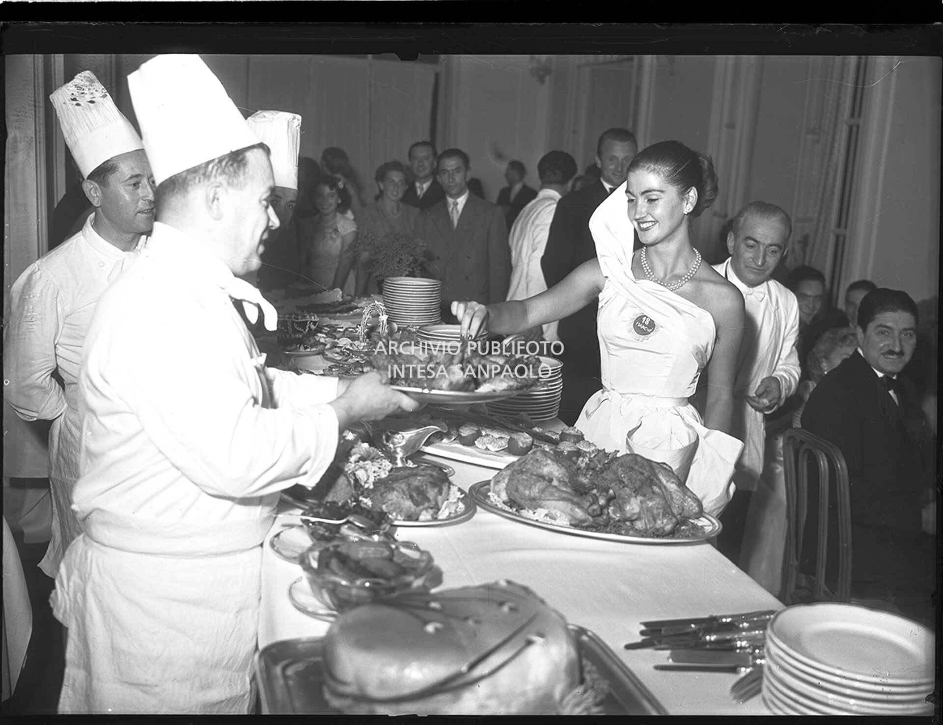 Mariella Giampieri, Miss Italia 1949, si serve da mangiare al buffet